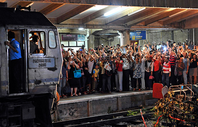 The crowd cheering and clicking their cameras as the engine for the 2nd last arriving Malayan Railway (KTM) train pulled into the Tanjong Pagar Railway station on 30 June 2011, which is the last day of operation for the station. From 1 July 2011, the trains will start and end their journeys at Woodlands Train Checkpoint in the north. ST Photo: Raj Nadarajan